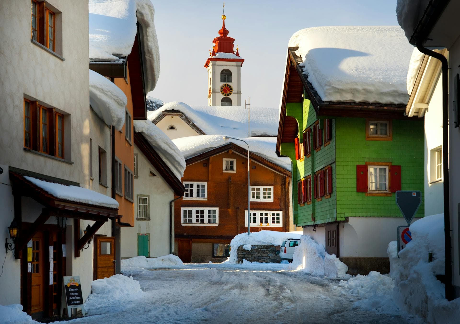 A snow-covered alpine village street with a clock-tower church, evoking Midway, Utah's Swiss-themed Heber Valley charm.