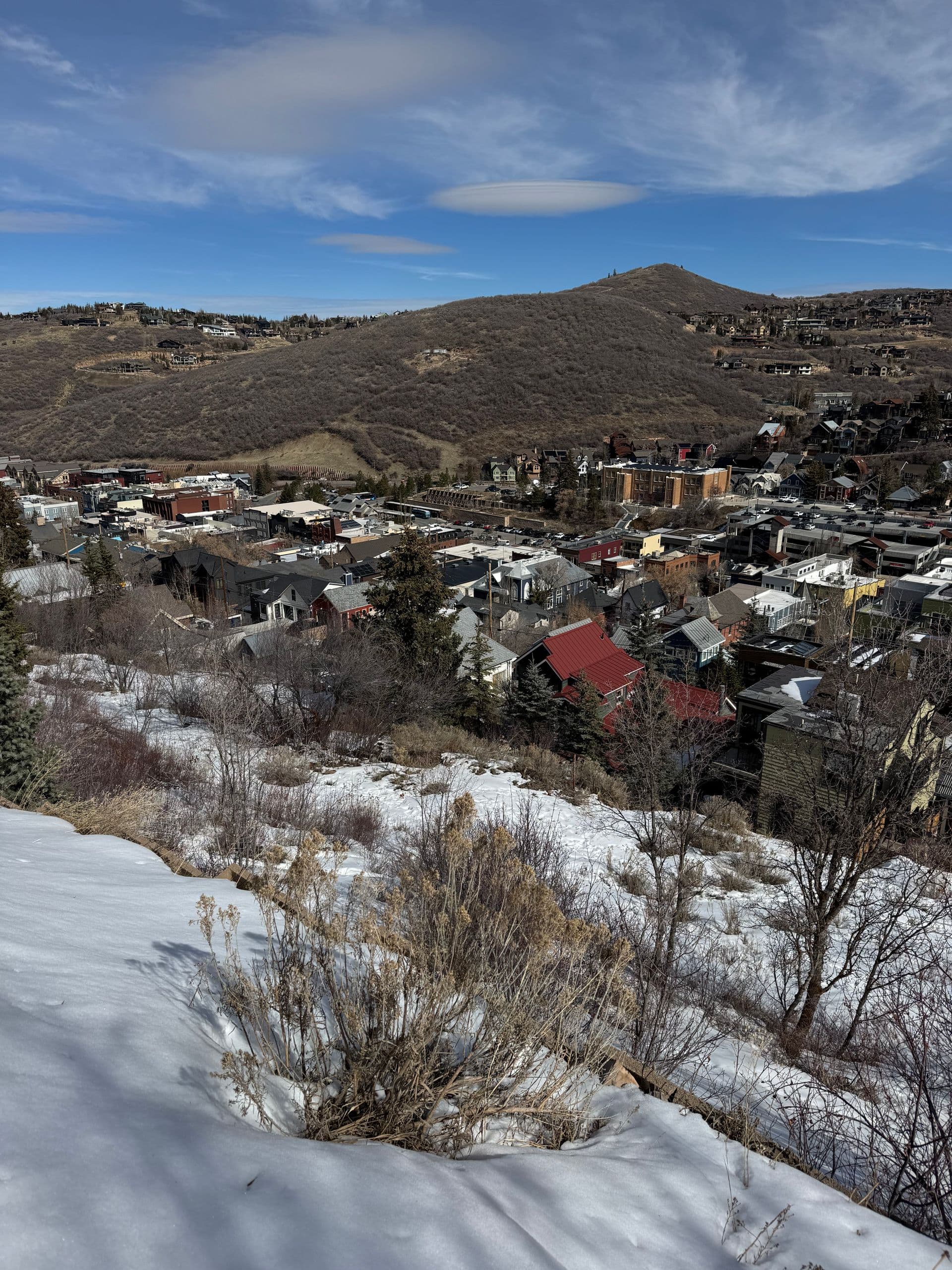 Snowy hillside view over Old Town Park City, Utah, with ski runs rising above Main Street.